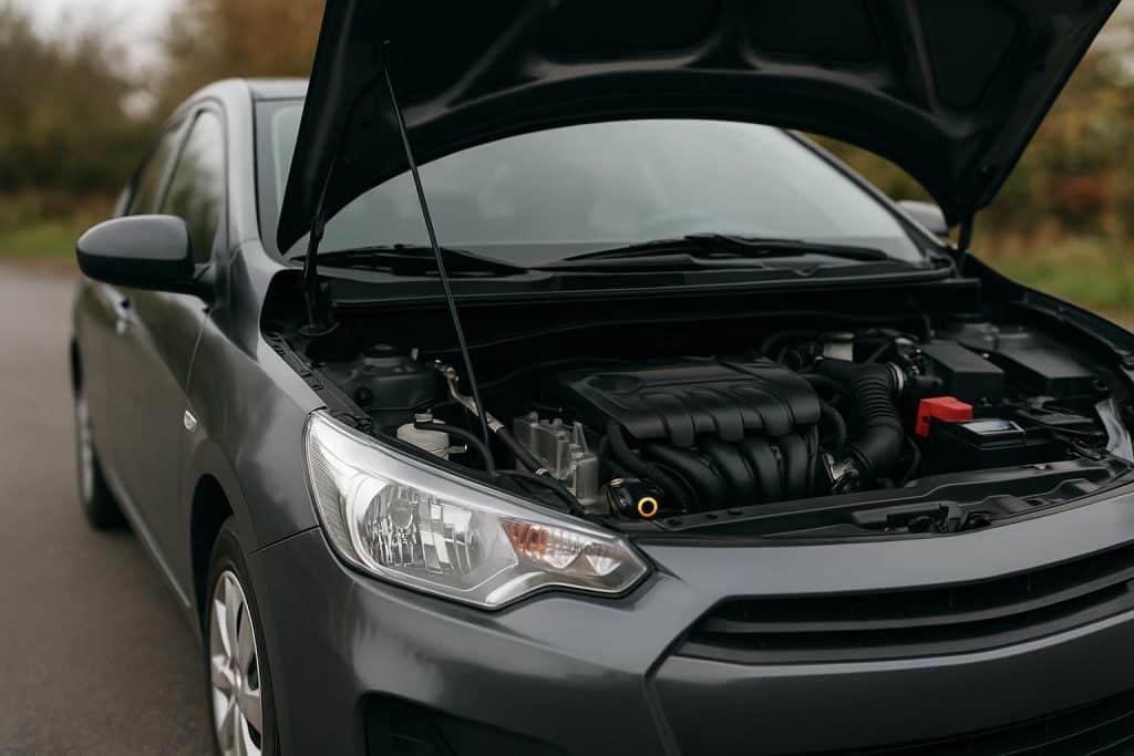 Mechanic inspecting car engine during routine tune-up in auto repair shop for maintenance tips